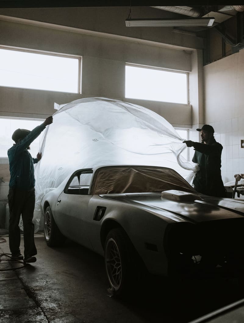 Pulling the cover off a project car in the shop